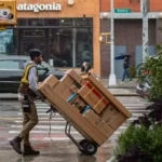 A professional delivery man with packages. he is displaying goods and service supply chain in one picture