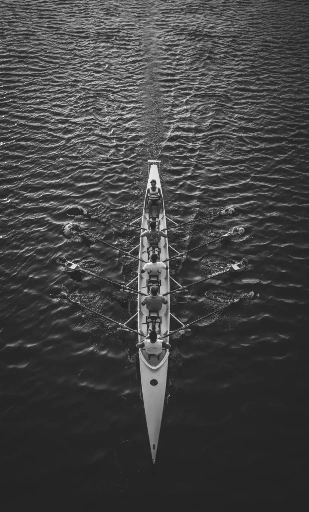 People rowing a boat together in a seamless collaboration chain